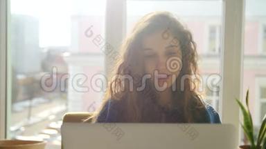 年轻女子在窗口前浏览电脑